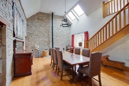 a dining room with a wooden table and chairs at Home Farm B&B - Poppy Room in Forfar