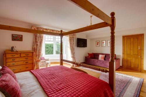 ein Schlafzimmer mit einem großen Bett mit einer roten Decke in der Unterkunft Home Farm B&B - Poppy Room in Forfar