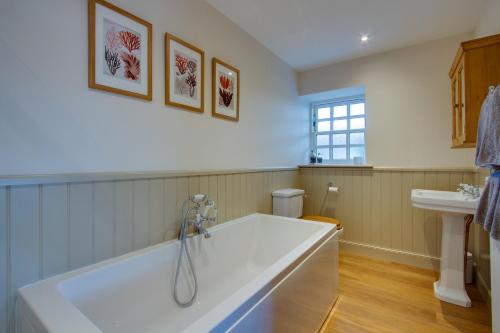 a bathroom with a large tub and a sink at Home Farm B&B - Poppy Room in Forfar