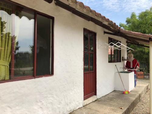 a man standing outside of a house with a broom at Cabañas Campestres en Villavicencio in Villavicencio