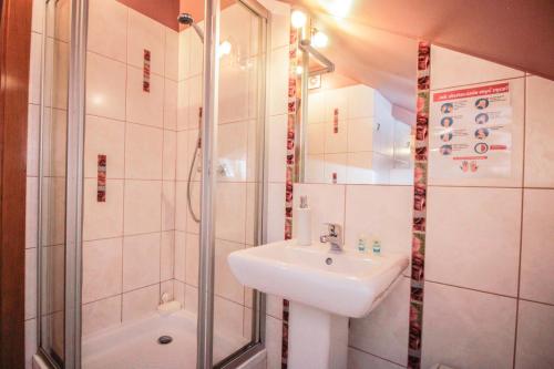 a bathroom with a sink and a shower at Bar-Kawiarnia BASIA Pokoje Gościnne in Szczyrk