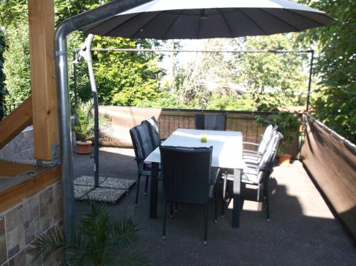 a patio with a table and chairs and an umbrella at Ferienappartement Pirmasens in Pirmasens