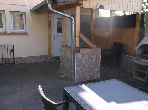 a patio with a grill and a table and a building at Ferienappartement Pirmasens in Pirmasens