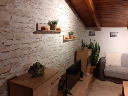 a living room with a stone wall and a couch at The view attic in Ioannina