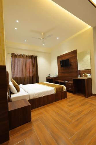 a hotel room with a bed and a television at The Grand Tree Hotel in Agra