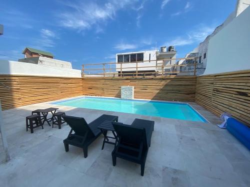 a swimming pool with chairs and a table next to a building at FRENTE PLAYA vista al mar, PISCINA DE USO EXCLUSIVO in Boca del Río