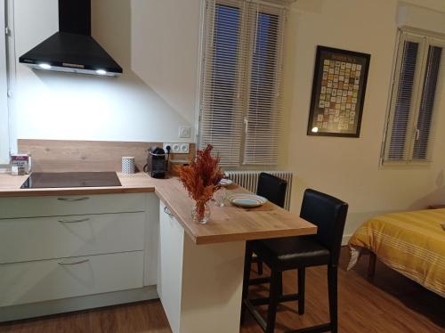 cocina pequeña con mesa y cama en Le Girond'Inn, en Libourne