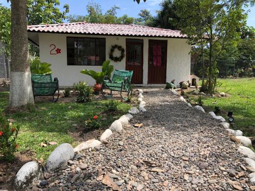 a small white house with a gravel driveway at Cabañas Campestres en Villavicencio in Villavicencio