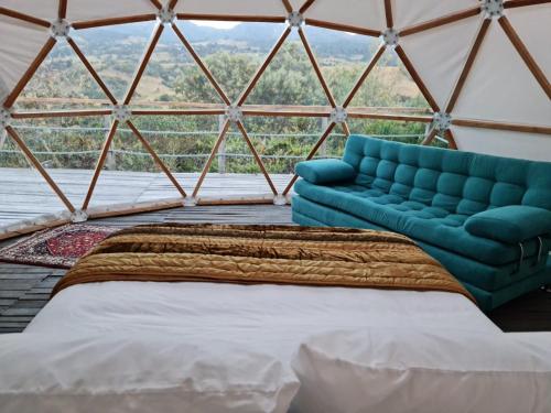 a room with a bed and a couch in a yurt at La Meca Glamping in Guasca