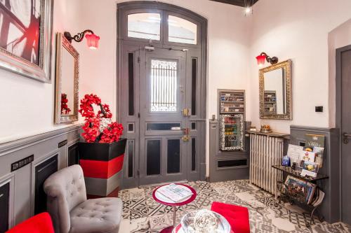 a room with a door and a vase with red flowers at Hôtel de Charme Le Provence in Salon-de-Provence