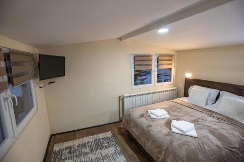 a bedroom with a bed with two towels on it at Apartmani SP Jovanovic in Crni Vrh