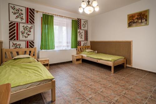 a bedroom with two beds and a window at Bence Apartman in Tiszabábolna
