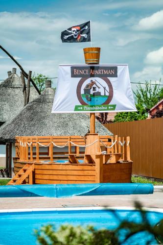 a large wooden boat with a sign in a pool at Bence Apartman in Tiszabábolna