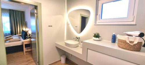 a white bathroom with a sink and a mirror at Villa Green Forest with wellness and heated salty pool in Hum