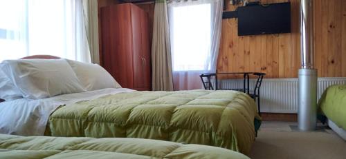 a bedroom with two beds and a flat screen tv at Hospedaje Ayelen in Ancud