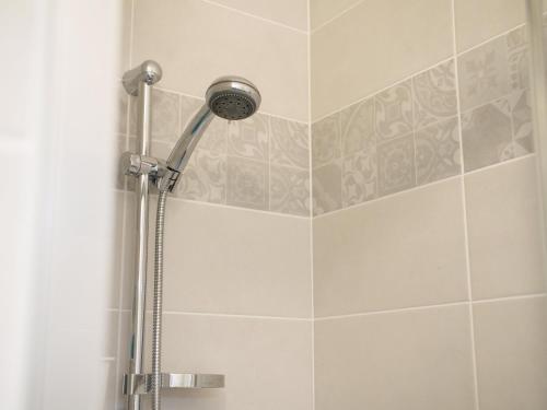 a shower with a shower head in a bathroom at Apt. neuf à 50m du port - Parking privé, ascenseur in Saint-Valery-sur-Somme