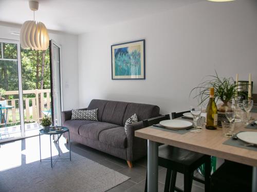un salon avec un canapé et une table dans l'établissement Apt. neuf à 50m du port - Parking privé, ascenseur, à Saint-Valery-sur-Somme