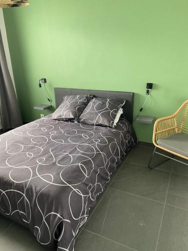 a bedroom with a bed and a chair at ROMARINE in Sainte-Clotilde