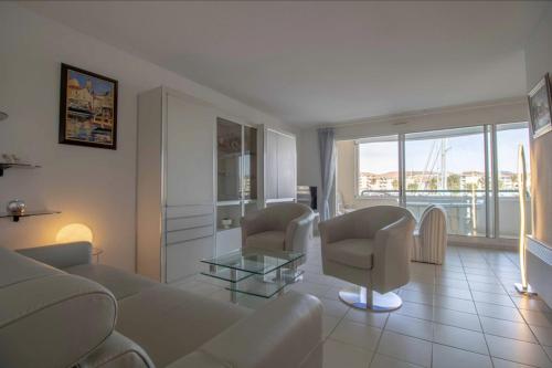 un salon avec un canapé, des chaises et une table dans l'établissement Apartment With Balcony And View On The Port, à Fréjus