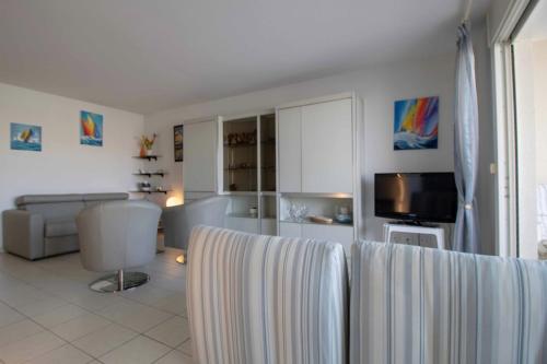 un salon avec un canapé et une télévision dans l'établissement Apartment With Balcony And View On The Port, à Fréjus