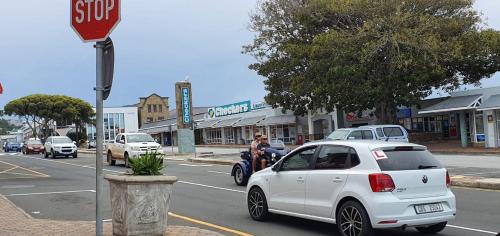 a white car is parked next to a stop sign at TinyApartment@Mosselbay - Entire 1 Bedroom Apartment Mossel Bay Central in Mossel Bay