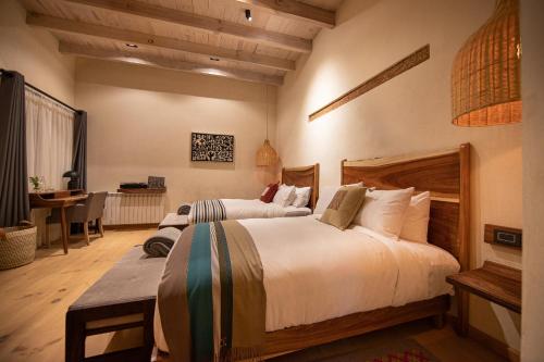 a bedroom with two beds and a desk in it at Taller de Juan - Casa Hotel in San Cristóbal de Las Casas