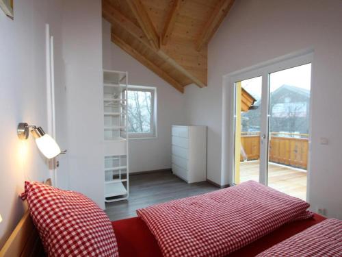 a bedroom with a red bed and a balcony at Haus Seltschach in Arnoldstein
