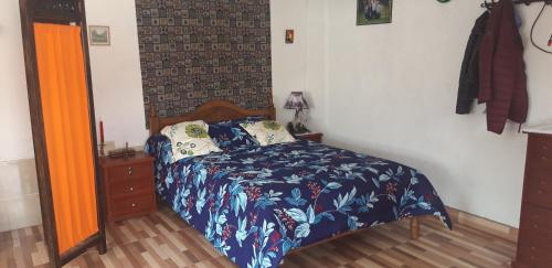 sypialnia z łóżkiem z niebieską kołdrą w obiekcie Häuschen nahe Cotopaxi-House near Cotopaxi w mieście Machachi