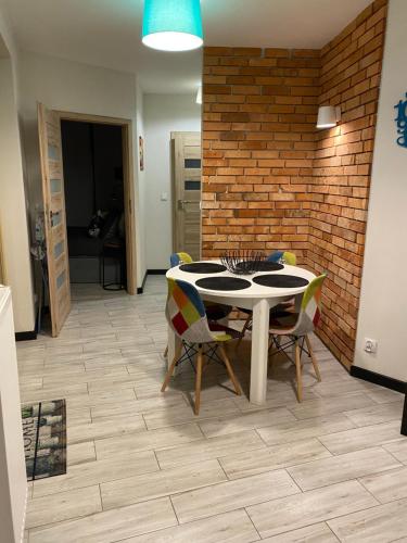 a dining room with a table and chairs and a brick wall at Ariel in Świnoujście