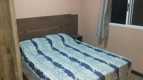 a bed with a blue comforter in a room at Apartamento Armonía 01 in Punta Colorada