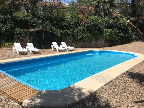 - une piscine bleue avec des chaises et un groupe d'acariens dans l'établissement Casa Rural COMPLETA Finca Los Conventos en Adamuz; Córdoba, à Adamuz