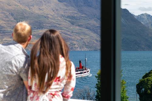 
a man and a woman looking at a boat in the water at Crowne Plaza Queenstown, an IHG Hotel in Queenstown
