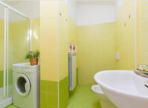 uma casa de banho com uma máquina de lavar roupa e um lavatório em Punta Ovest a due passi del MARE em Marina di Montenero