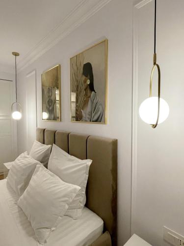a bedroom with a bed and two pictures on the wall at Selling Sunset Apartments in Timişoara