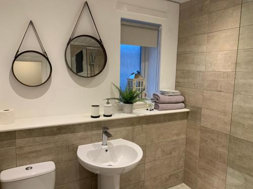 a bathroom with a sink and a mirror at Kincraig Apartment in Ayr