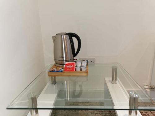 uma máquina de café sentada numa mesa de vidro em Coliemore Acommodation Dalkey em Dalkey