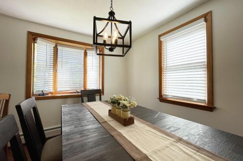 a dining room with a table and a chandelier at Spacious, Sunny Lake House! Close to ski trails. in Windsor