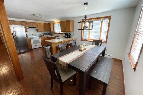 a kitchen with a wooden table and a dining room at Spacious, Sunny Lake House! Close to ski trails. in Windsor