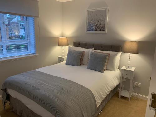 a bedroom with a large bed with two lamps at Kinfirth Apartment in Ayr