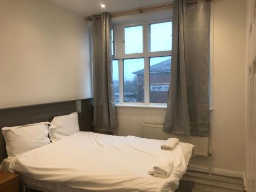 a bed in a room with a window at Spacious Entire Two Double Bedrooms Flat, N 3 in Great Yarmouth
