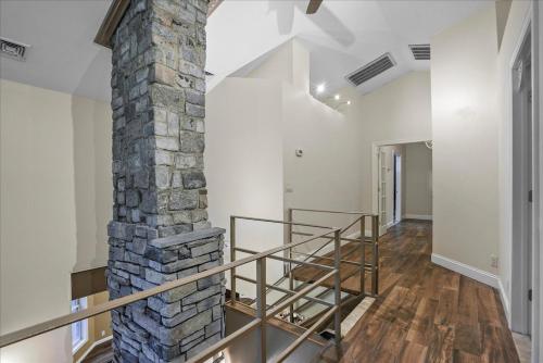 una escalera en una casa con un pilar de piedra en Charming 3BR 3Bath In Brilliant Location!, en Monroe