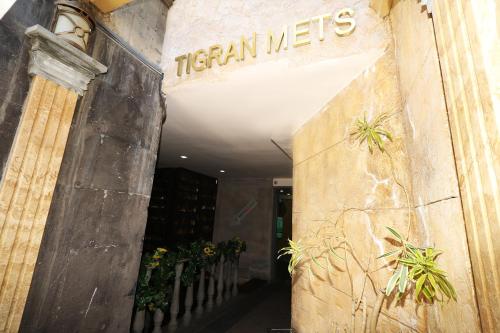an entrance to a building with a sign that reads texan interests at Hotel Tigran Mets Yerevan in Yerevan