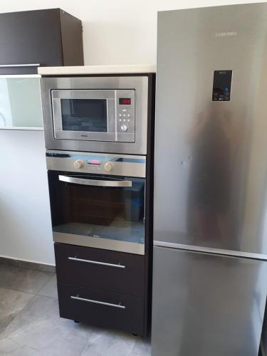 a microwave and a refrigerator in a kitchen at Noclegi 24/h Leszczynek in Kutno