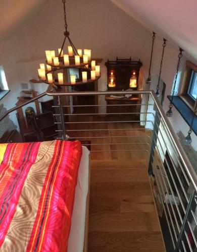 Pokój z klatką schodową, łóżkiem i żyrandolem w obiekcie Hof Tilia w mieście Hahnstätten