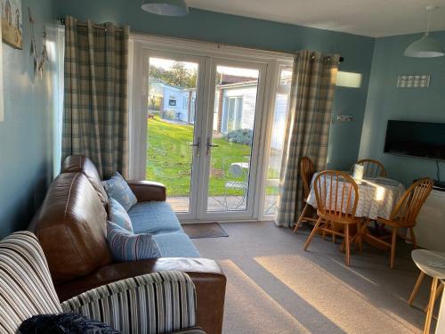 a living room with a couch and a table at Driftwood WINTERTON VALLEY ESTATE Dog Friendly in Winterton-on-Sea