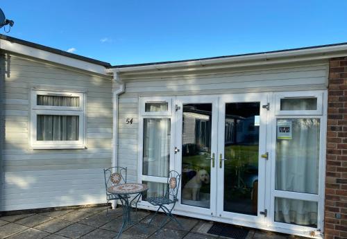 a screened porch with a door and a chair at Driftwood WINTERTON VALLEY ESTATE Dog Friendly in Winterton-on-Sea