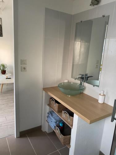 une salle de bain avec un lavabo vert et un miroir dans l'établissement Chaleureux T2 30 m2 et sa terrasse bois 18 m2, à La Rochelle