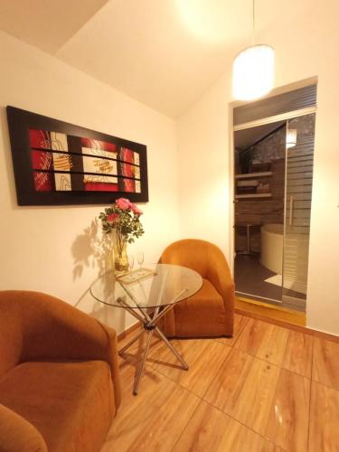 a living room with a glass table and two chairs at Monterrico Hotel Perú in Lima