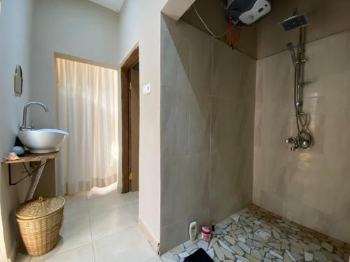 a bathroom with a sink and a shower with a sink at POMBO KUNDA in Sanyang