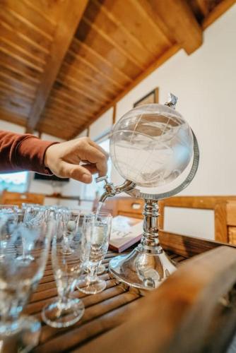 a person is pouring wine into glasses on a table at Cabana Trei Brazi Cacica in Cacica